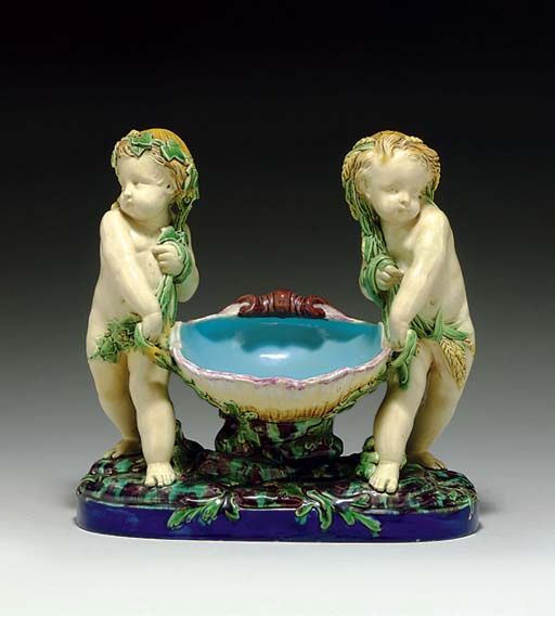 A MINTON MAJOLICA FIGURAL SWEETMEAT DISH EMBLEMATIC OF SPRING AND .