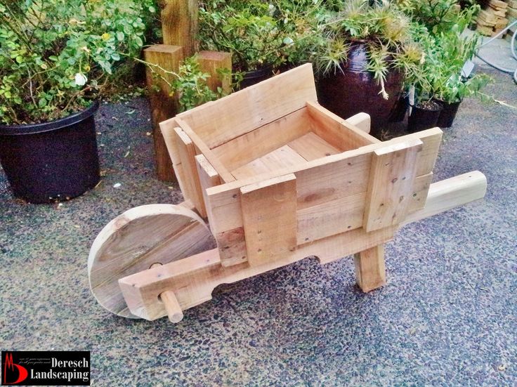 wheelbarrow planter/garden feature made of upcycled pallet wood .