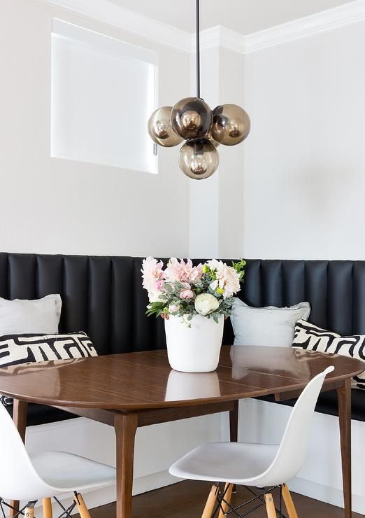 Contemporary dining nook is filled with an L shaped black vinyl .