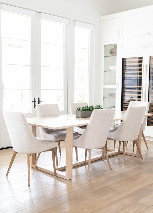 Light gray dining tables surround an oak dining table placed in .