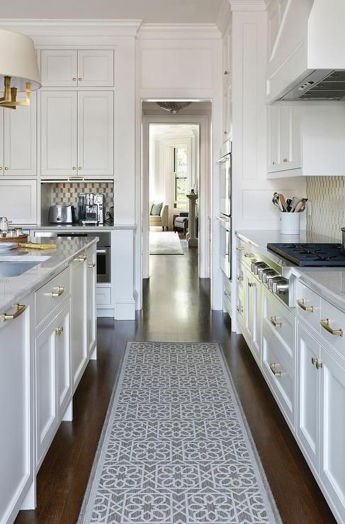 Stunning white kitchen boasts a gray trellis runner placed between .