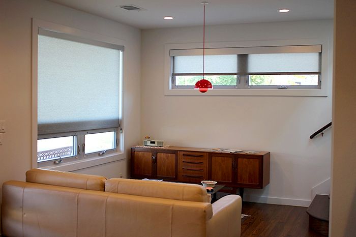 Hunter Douglas Roller shades in the living room with square head .