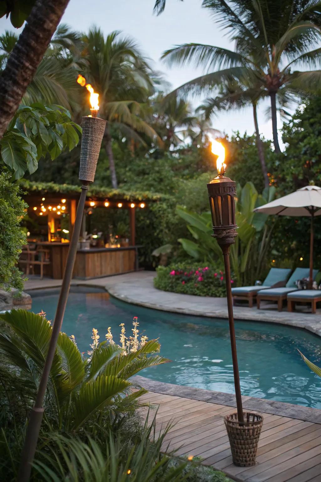 A tropical pool area illuminated by tiki torches.