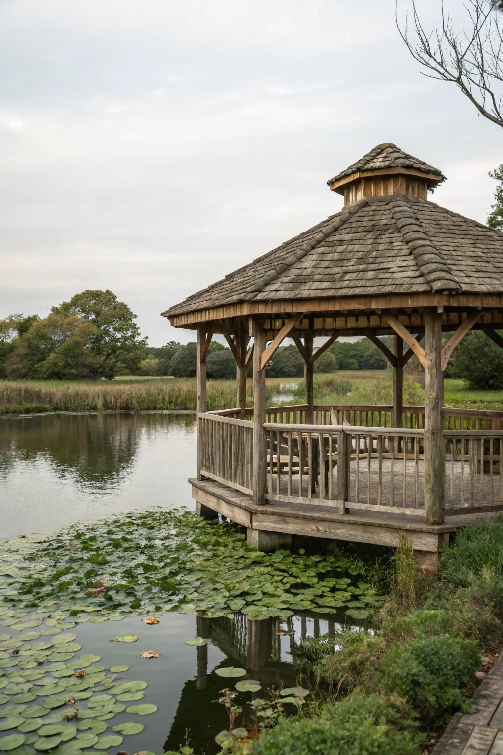 A rustic gazebo peacefully situated next to a pond.