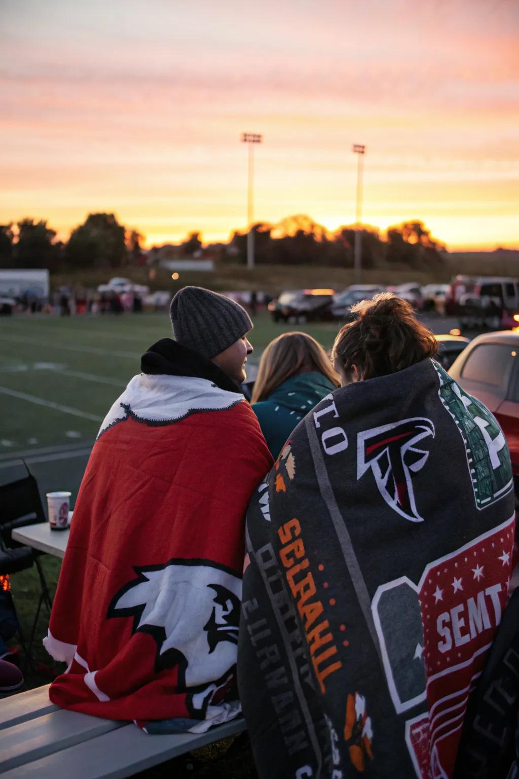 Group wrapped in team-themed blankets at a tailgate.
