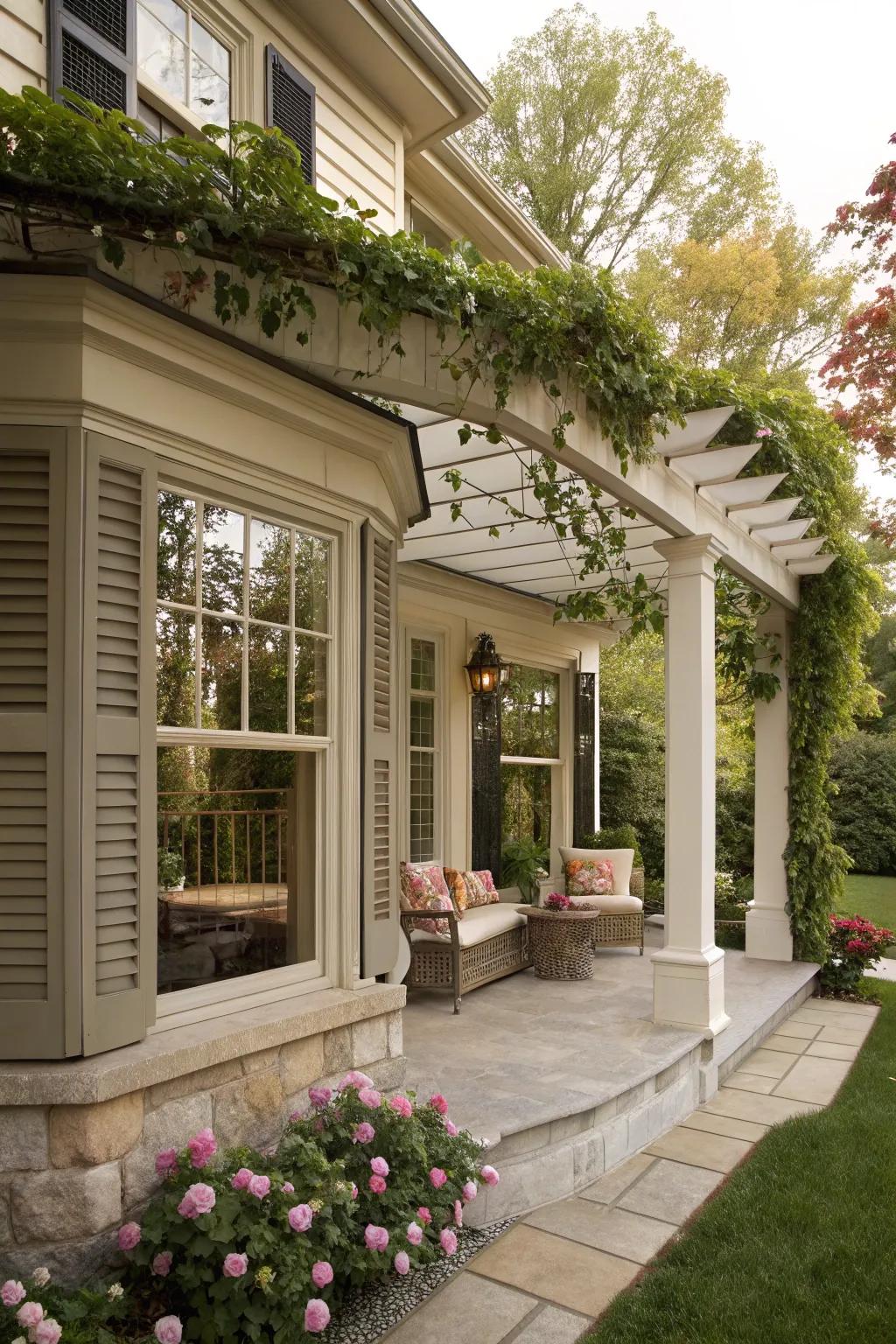 An elegant pergola adds shade and style to this front porch with a bay window.
