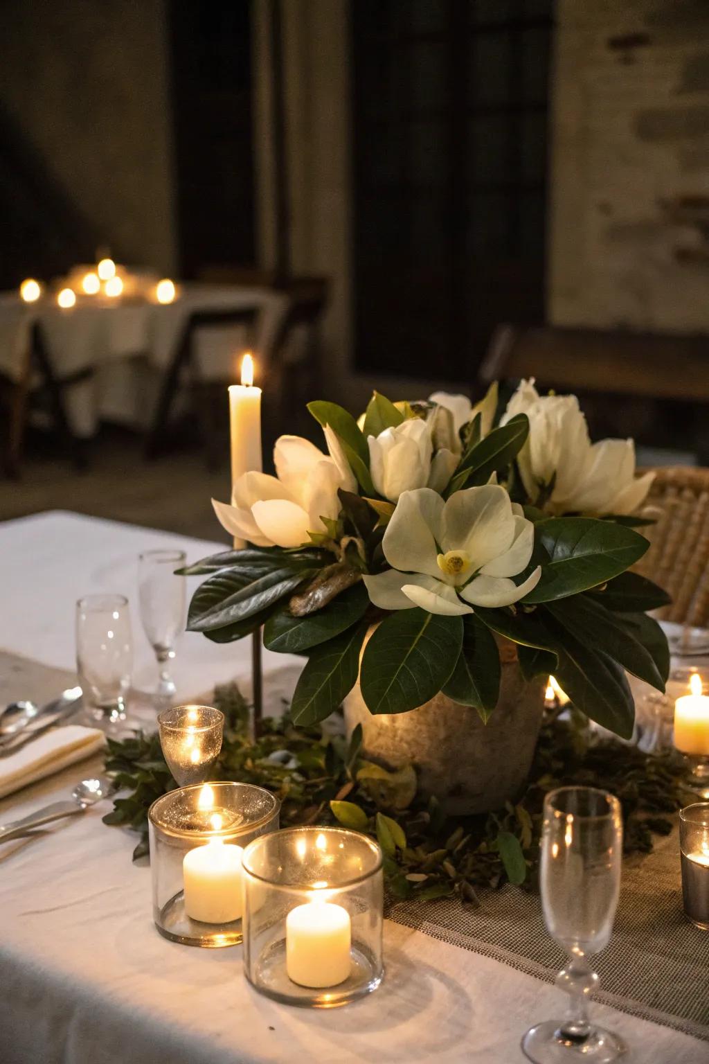 Candles enhance the ambiance of a magnolia centerpiece.