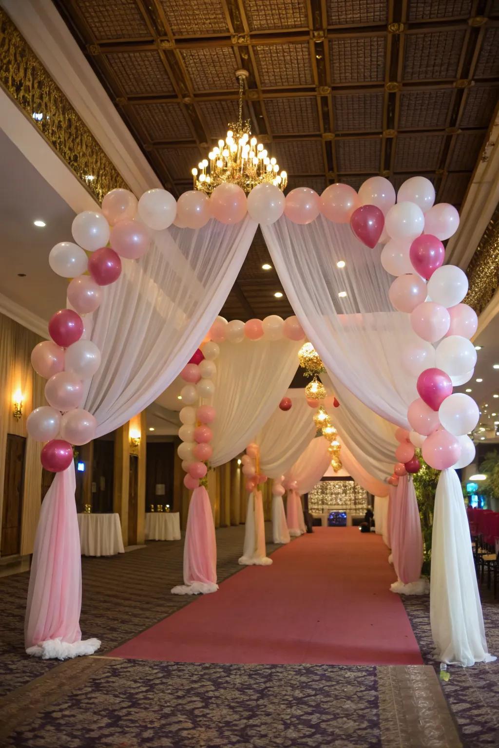 A balloon and fabric arch blends softness with festive flair.