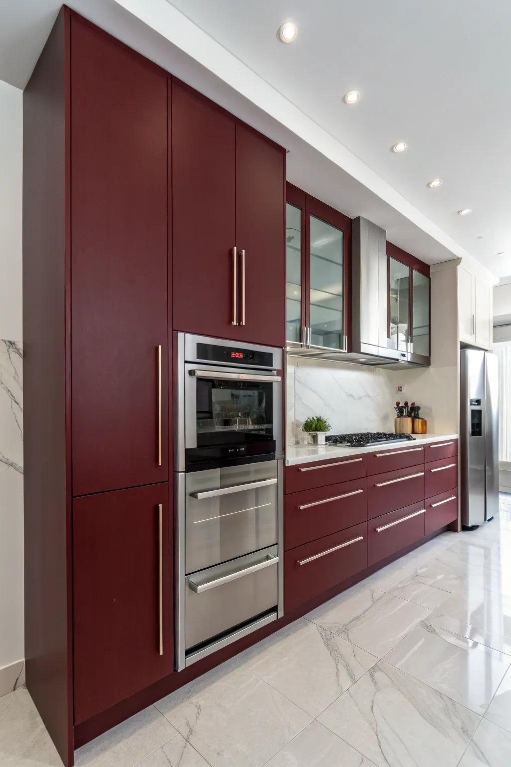 Minimalist kitchen design featuring handle-less dark red cabinets.