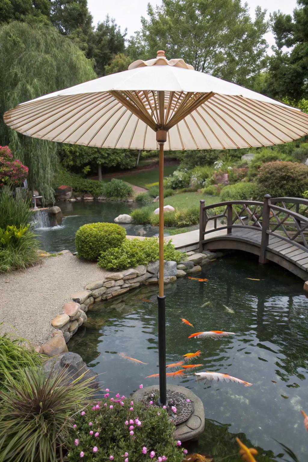 A broad garden umbrella providing shelter to a koi pond.