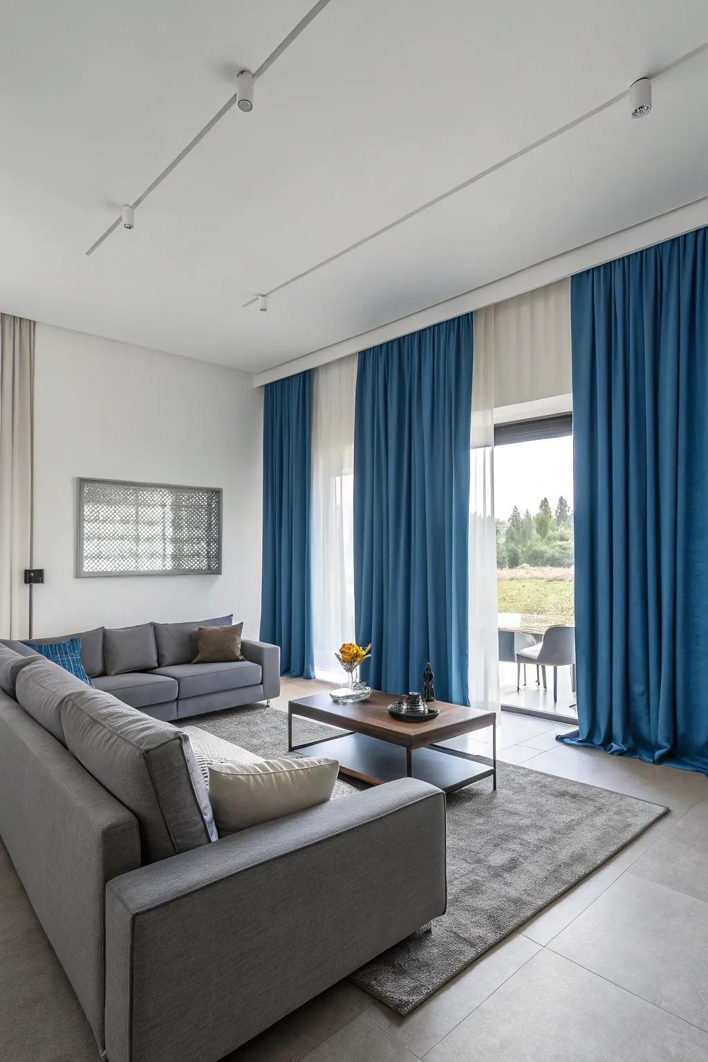 Sky-tinted drapes and 灰色的furniture fashion a contemporary, harmonious living space with a balanced color scheme.