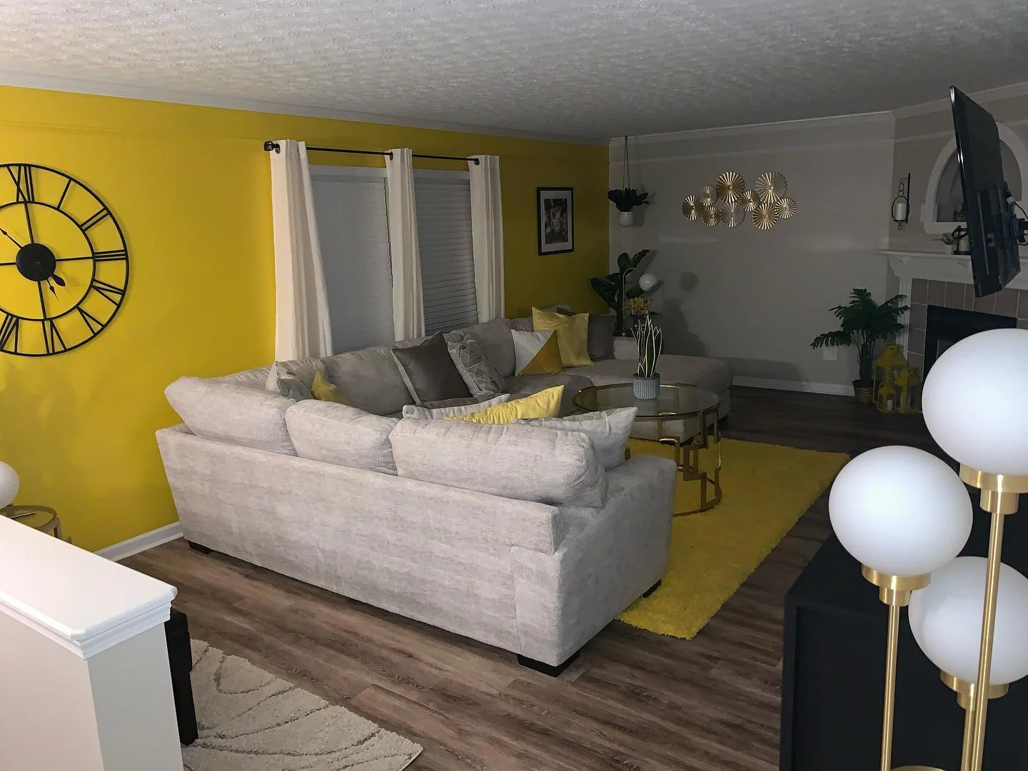 2. Bright Yellow Feature Wall with Modern Glam Accents (Yellow Walls Living Room Ideas)