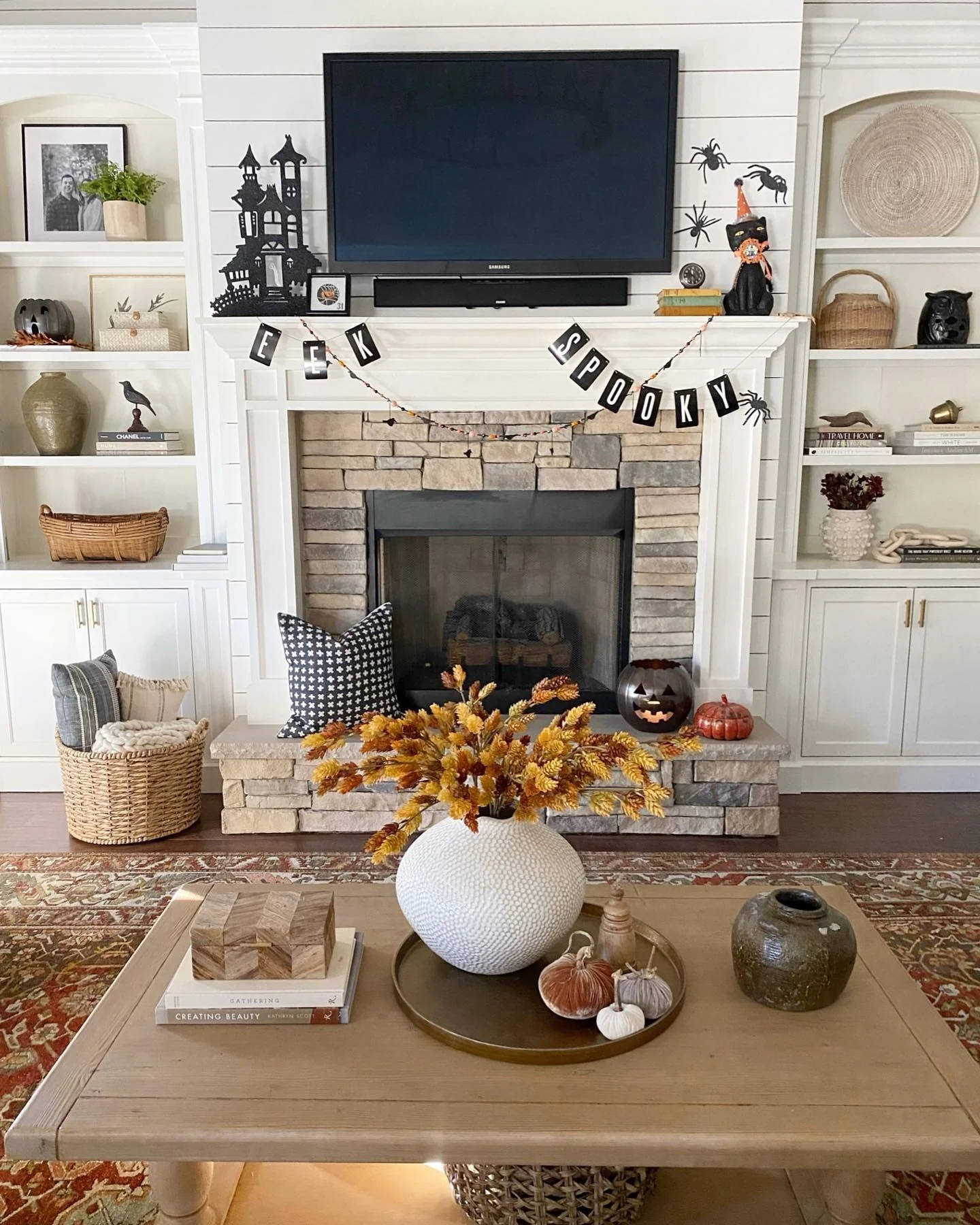 2. Classic Fireplace Styling with Black, White, and Amber (Fall Living Room Decorating Ideas)