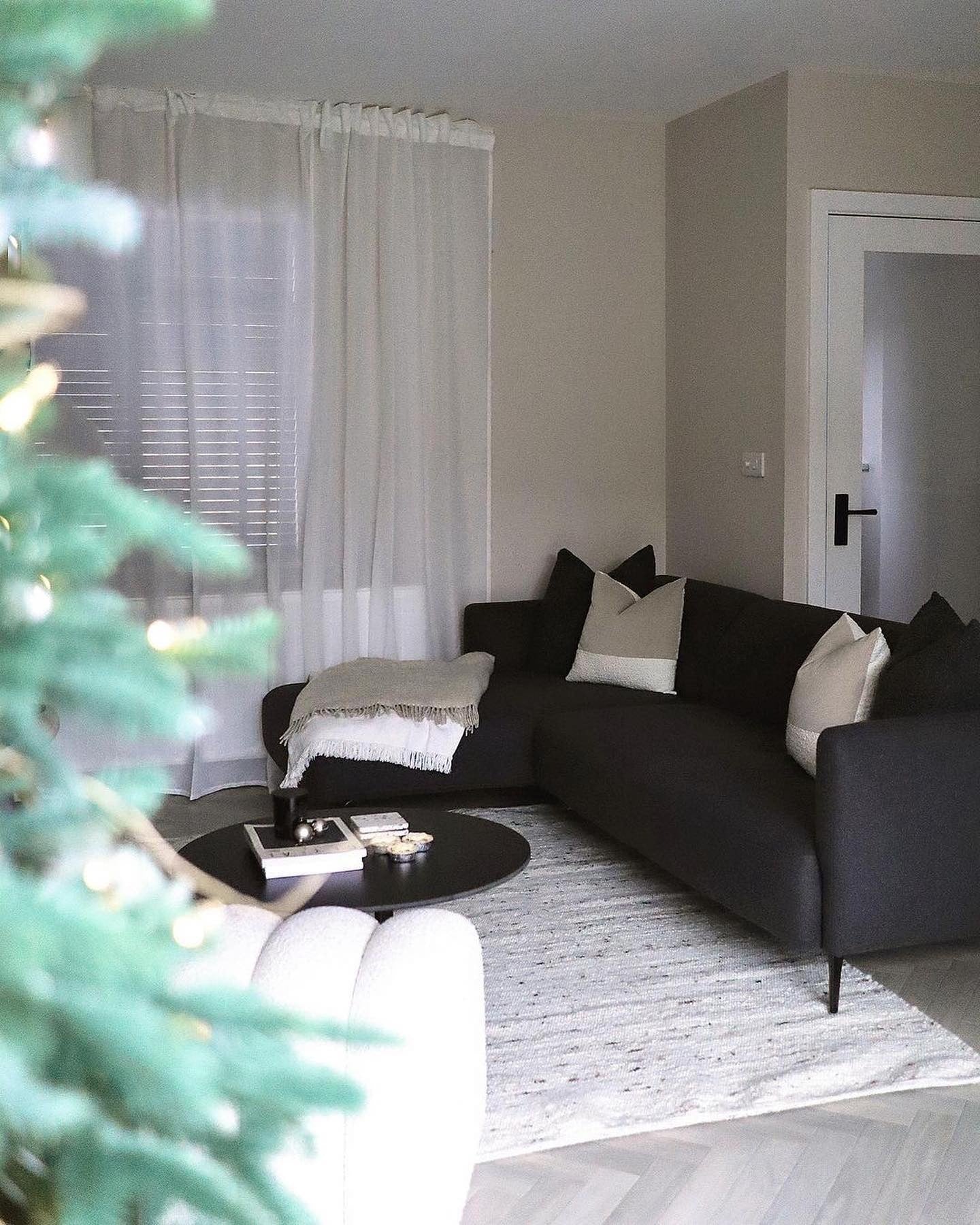 6. Black Sofa with Beige Walls & Soft Scandinavian Textiles (Dark Sofa Living Room Ideas)