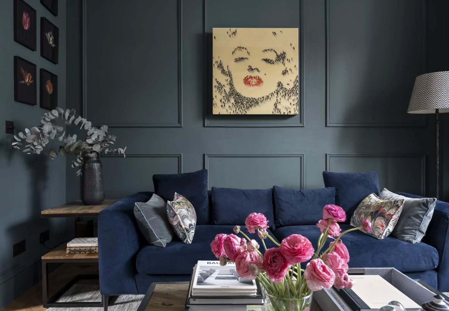 7. Midnight Blue Sofa with Moody Wall Paneling & Bold Florals (Dark Sofa Living Room Ideas)