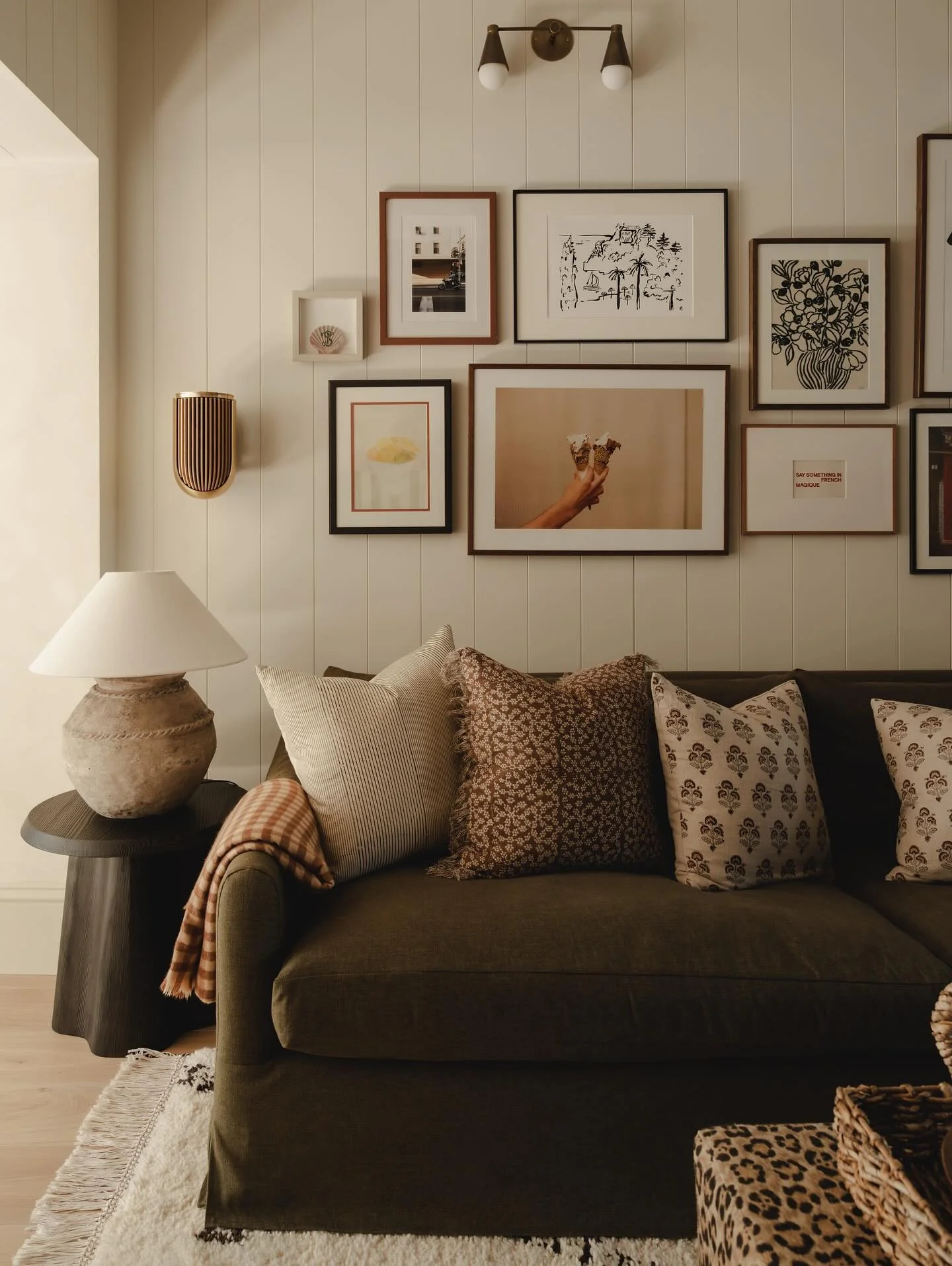 10. Olive-Green Sofa with Cream Walls & Warm Gallery Wall Styling (Dark Sofa Living Room Ideas)