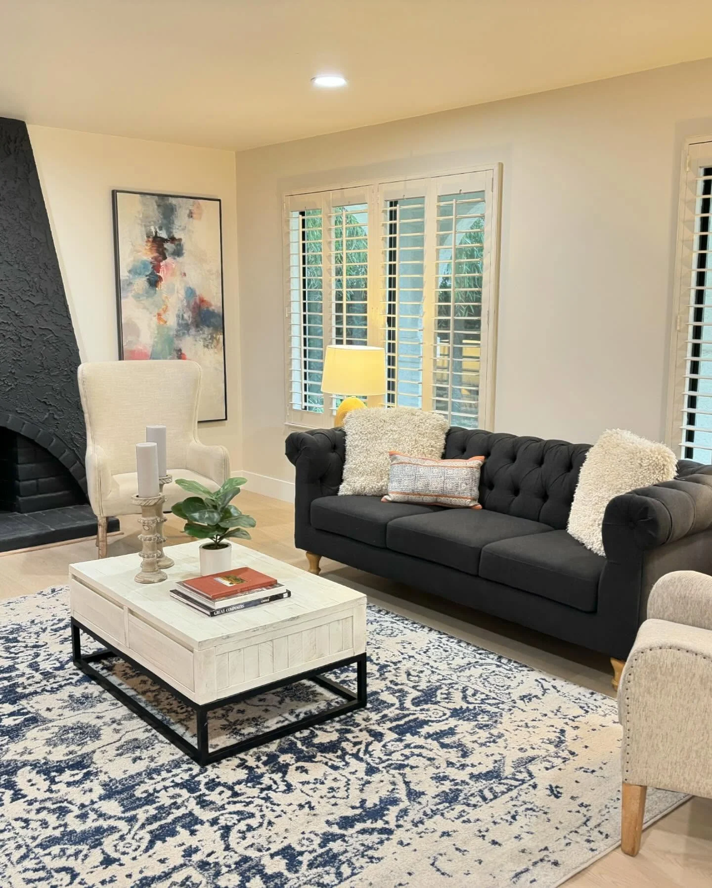 13. Classic Black Sofa with Blue-and-White Rug & Soft Neutral Accents (Dark Sofa Living Room Ideas)