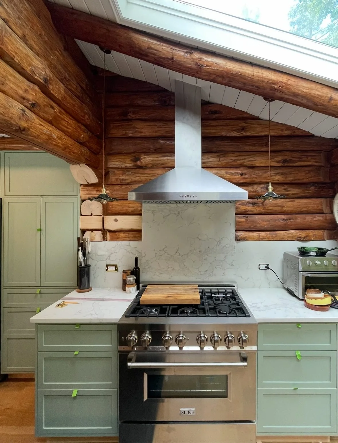 10. Soft Green Log Kitchen with Marble-Look Backsplash (Log House Kitchen Ideas)