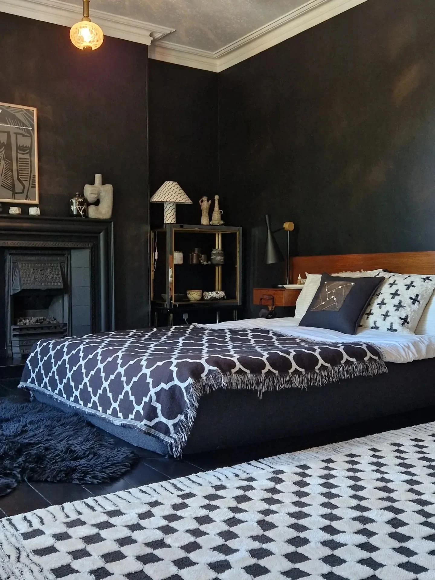 12. Matte Black Bedroom with Graphic Textiles + Warm Wood Tones (All Black Bedroom Ideas)