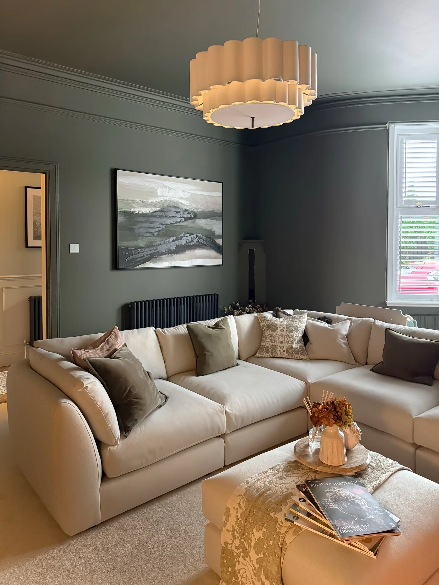 5. Deep Grey Walls with Soft Tan Sectional Seating (Grey and Tan Living Room Ideas)