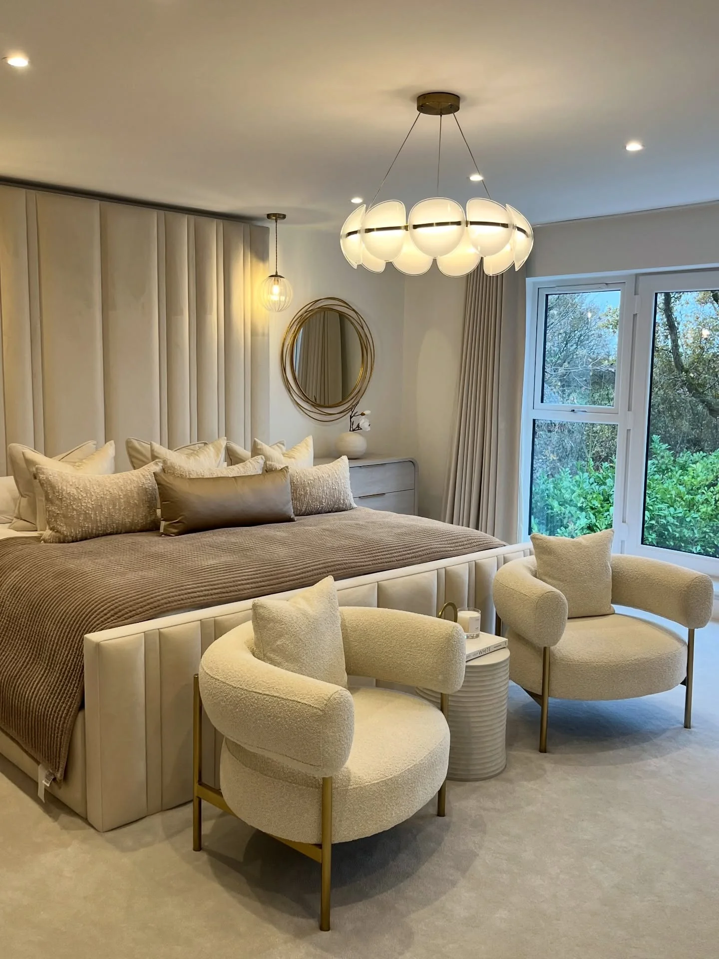 16. Sculpted Soft Neutrals with Statement Seating (Expensive Looking Bedroom Ideas)