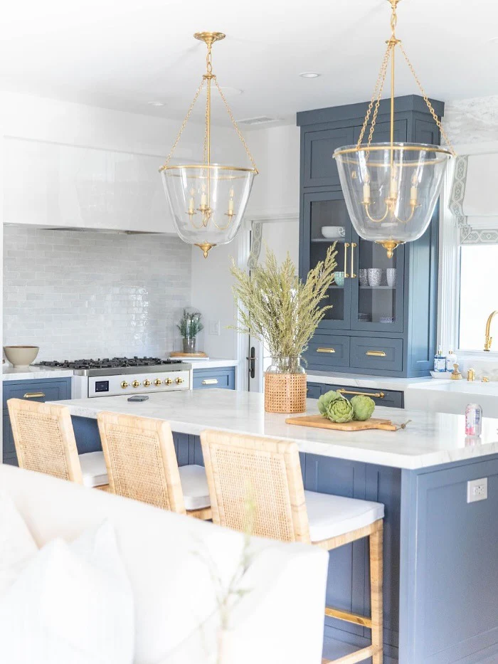 5. Navy and Brass Island with Statement Lighting (Coastal Kitchen Ideas)
