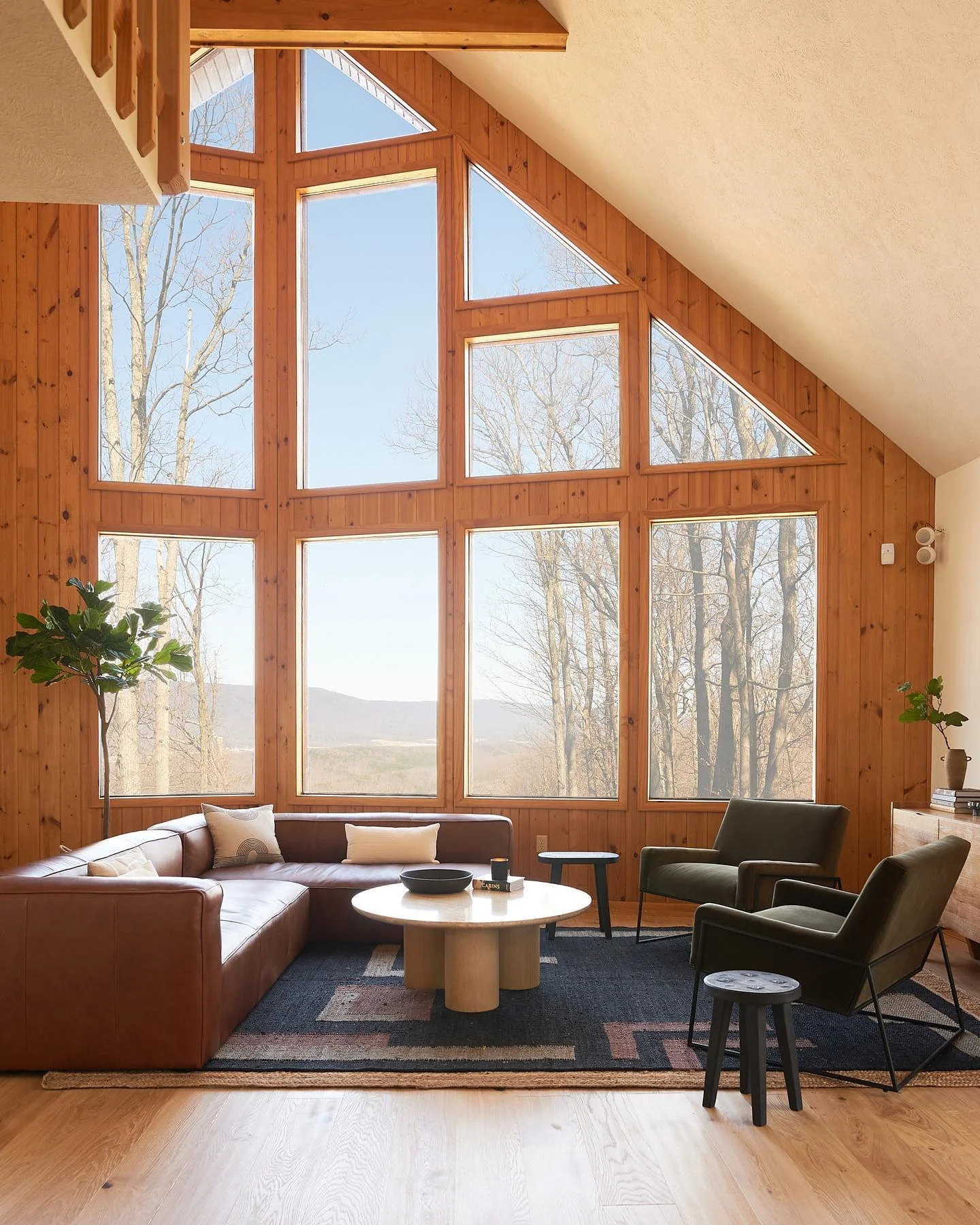 9. Bright A-Frame Cabin with Leather Sectional & Clean Architectural Lines (Cabin Living Room Ideas)