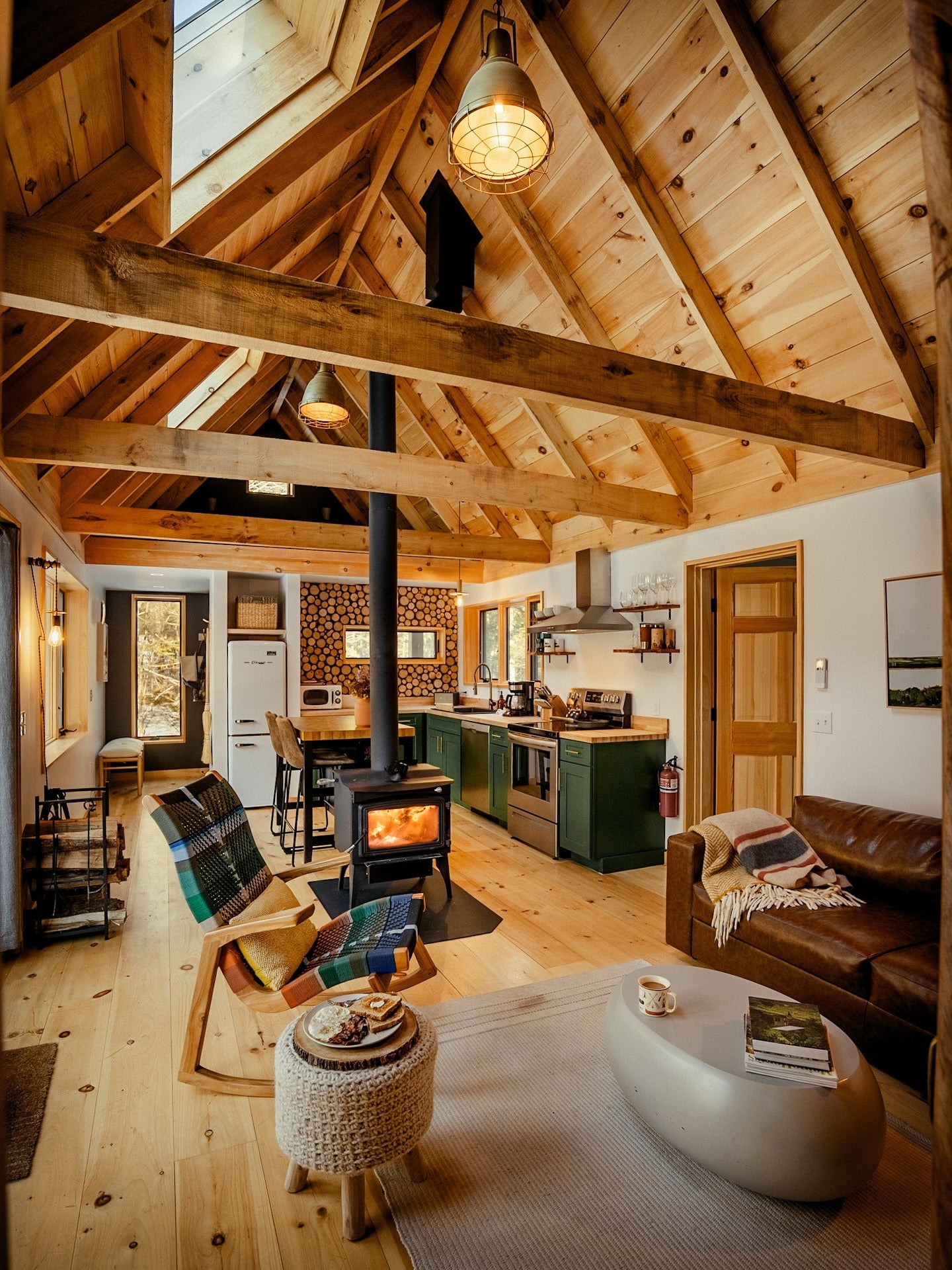 10. Rustic Cabin Gathering Space with Green Cabinetry & Wood-Burning Stove (Cabin Living Room Ideas)