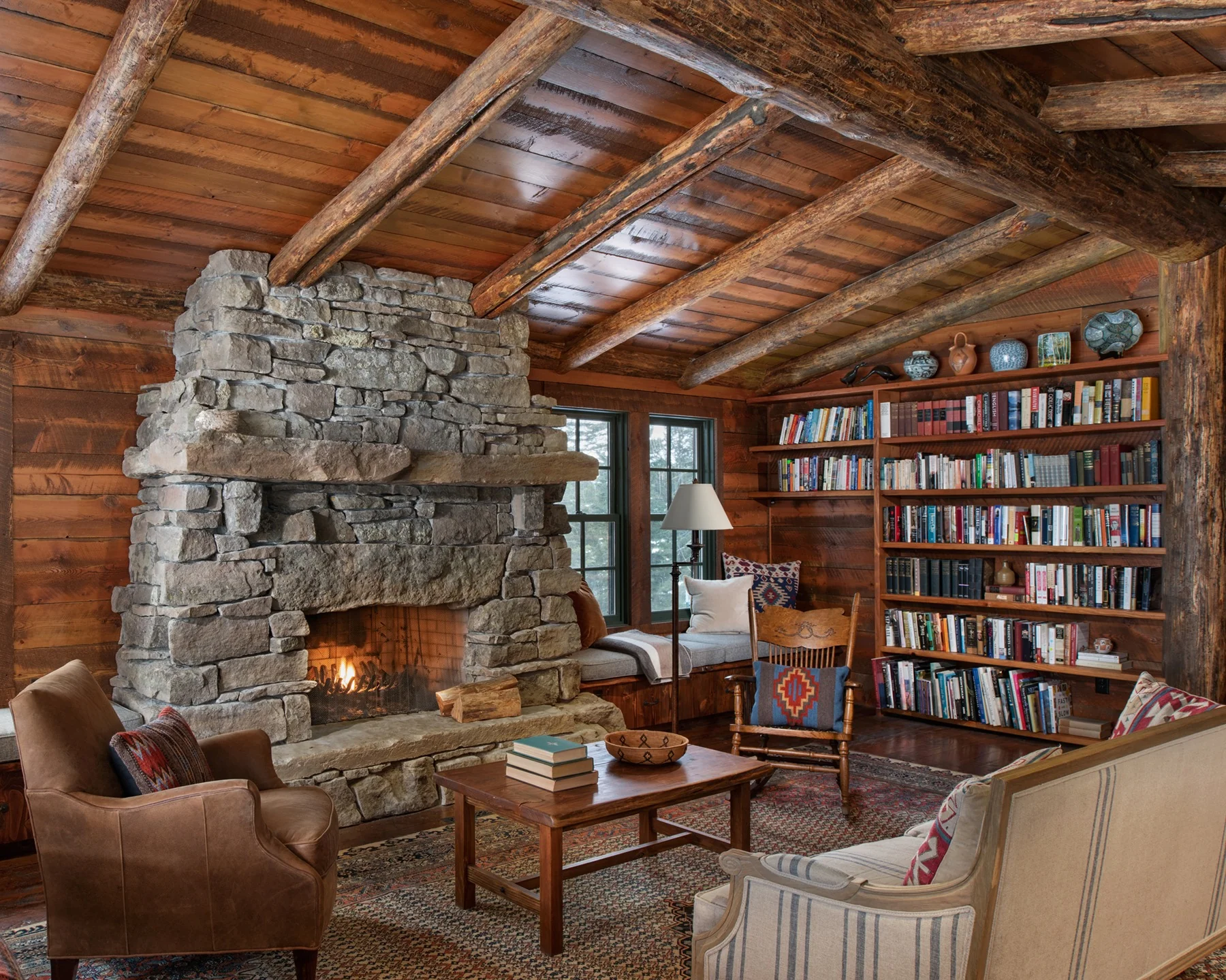 13. Rustic Library Cabin with Stone Hearth and Rich Timber Walls (Cabin Living Room Ideas)