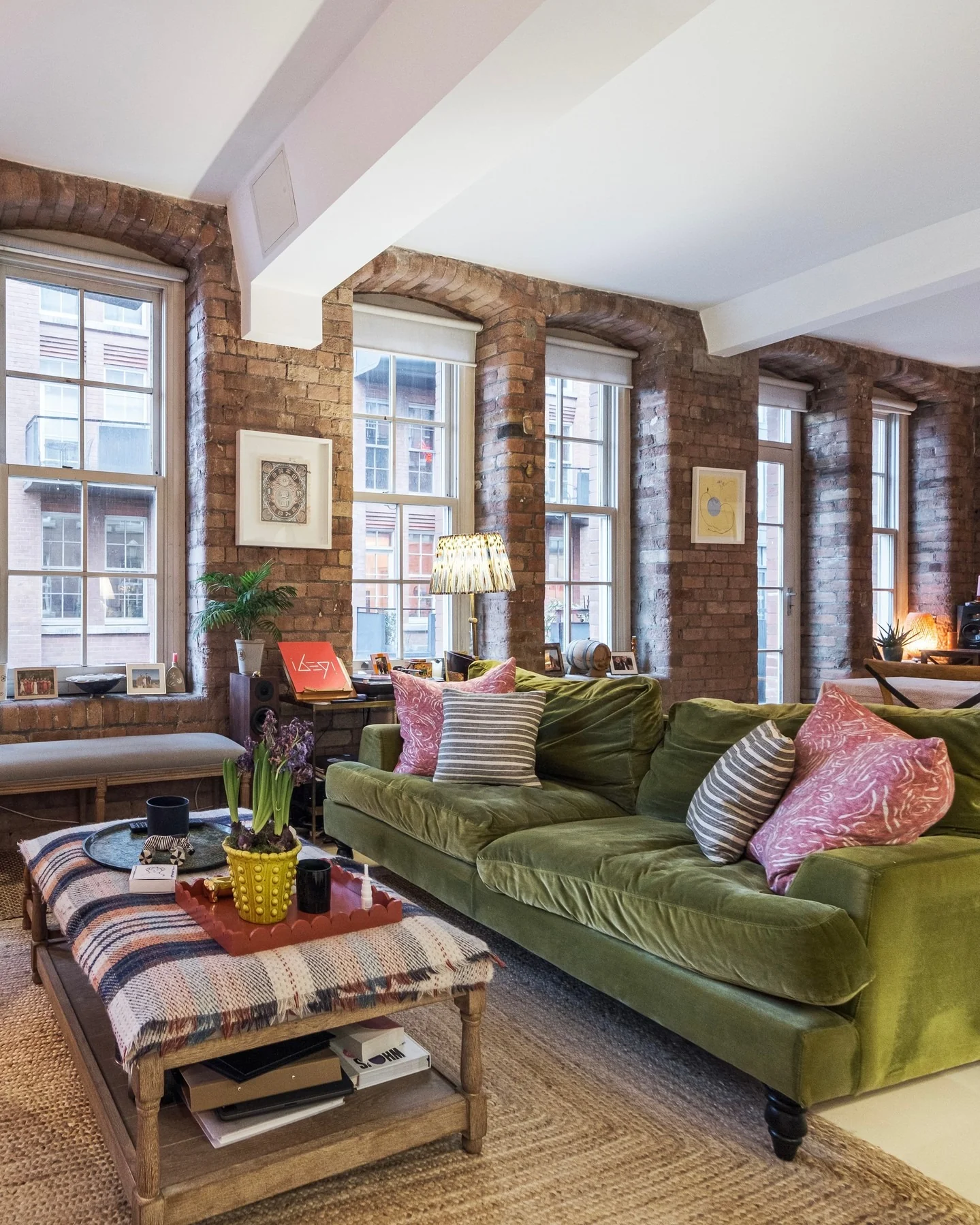 7. Brick-Walled Urban Loft with Green Velvet Comfort (Urban Living Room Ideas)