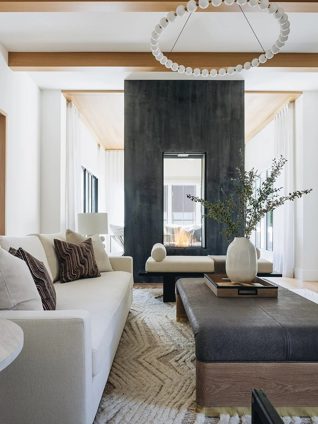 3. Modern Contrast Living Space with Ebony Fireplace Column (Brown and Black Living Room Ideas)