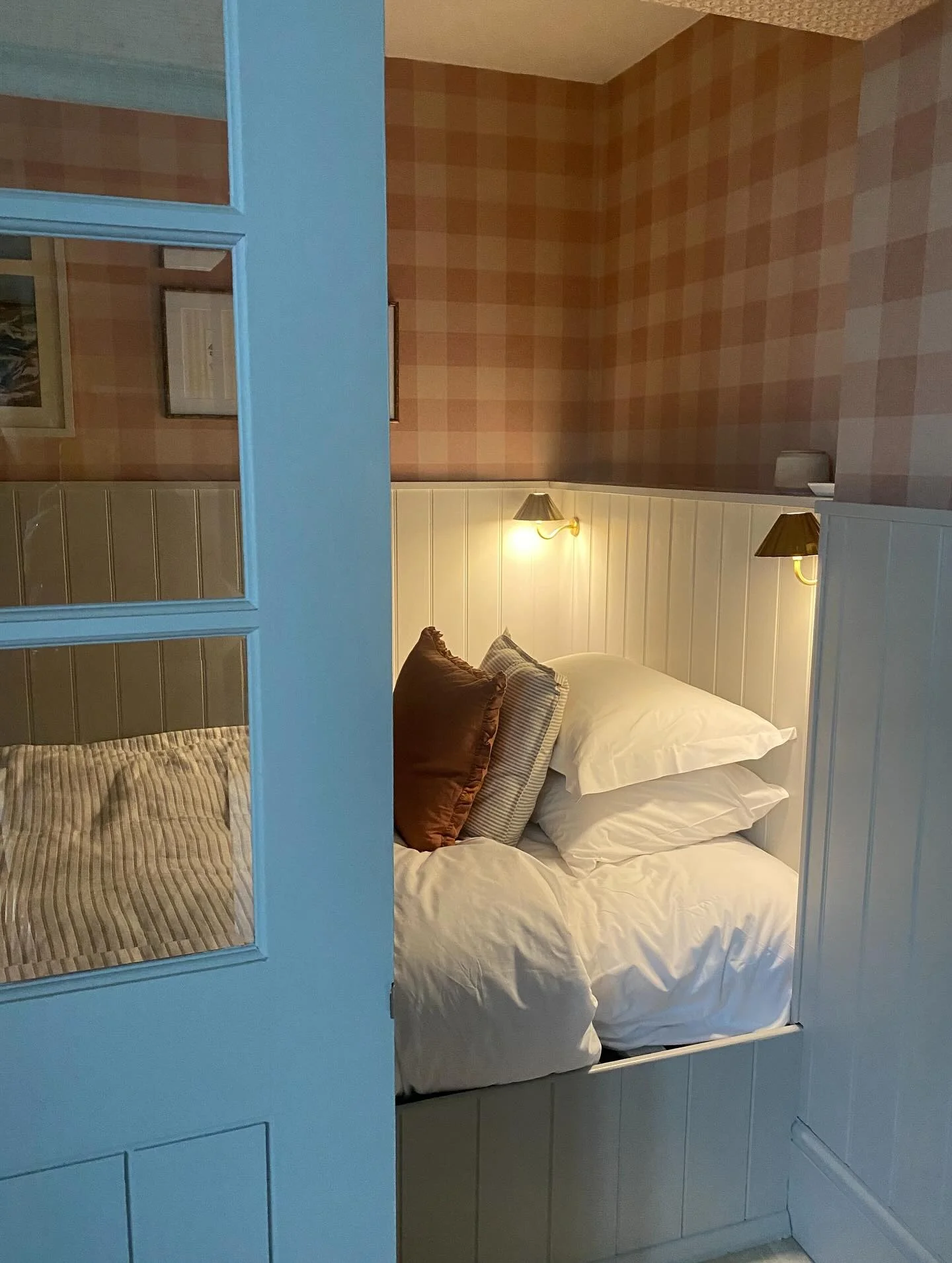 16. Cozy Plaid Alcove with Copper Glow (Cabin Bedroom Ideas)