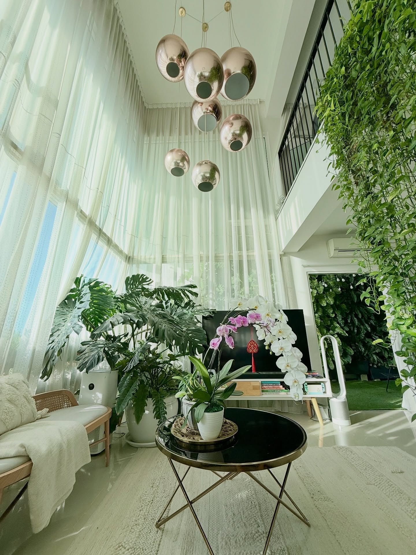 6. High-Ceiling Elegance with Tropical Energy (Living Room Ideas with Indoor Plants)