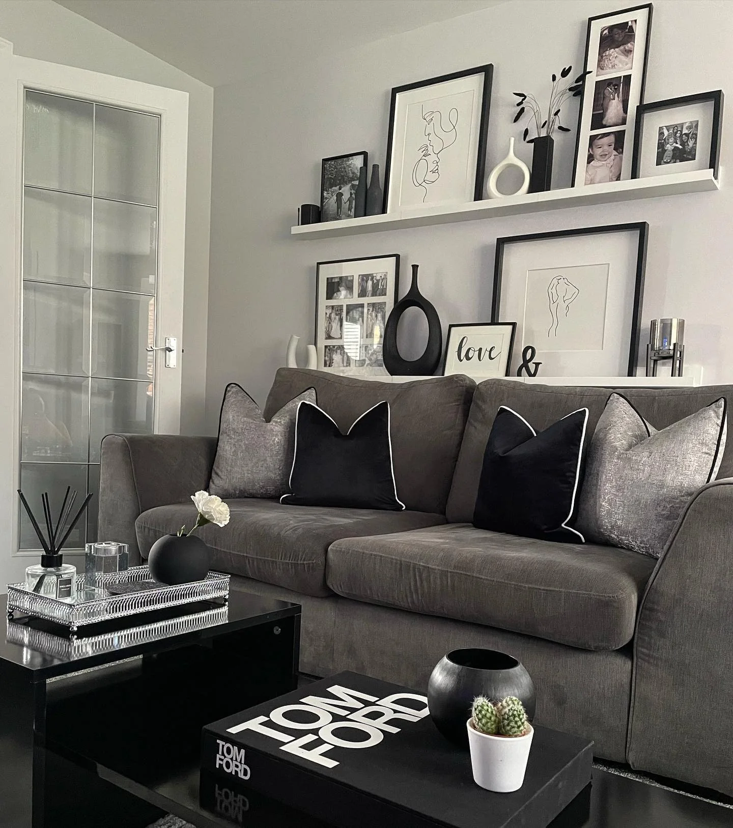 13. Monochrome Styling with Layered Wall Art (Grey, Black and White Living Room Ideas)