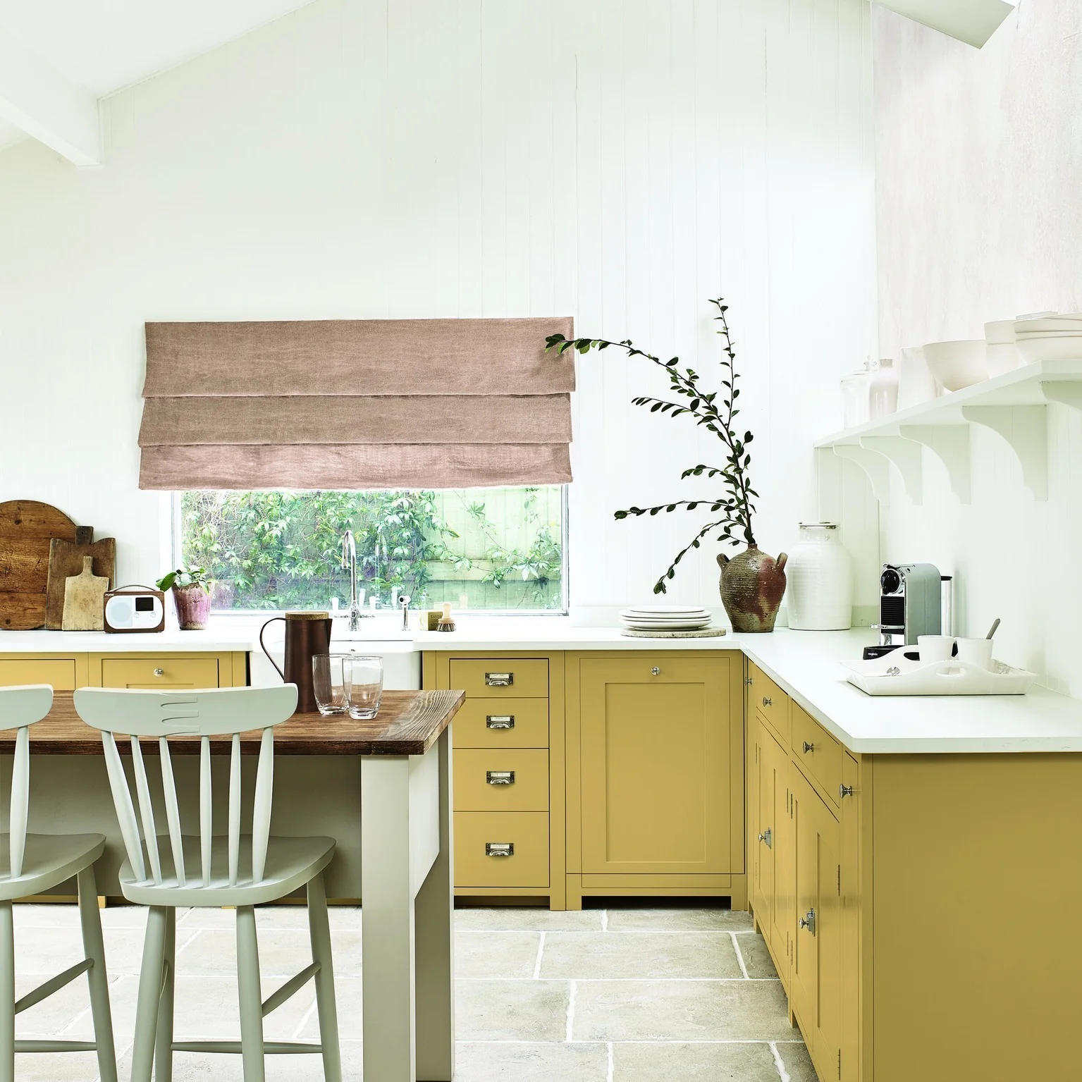 5. Soft Mustard Elegance with Natural Stone and White Accents (Yellow Kitchen Ideas)