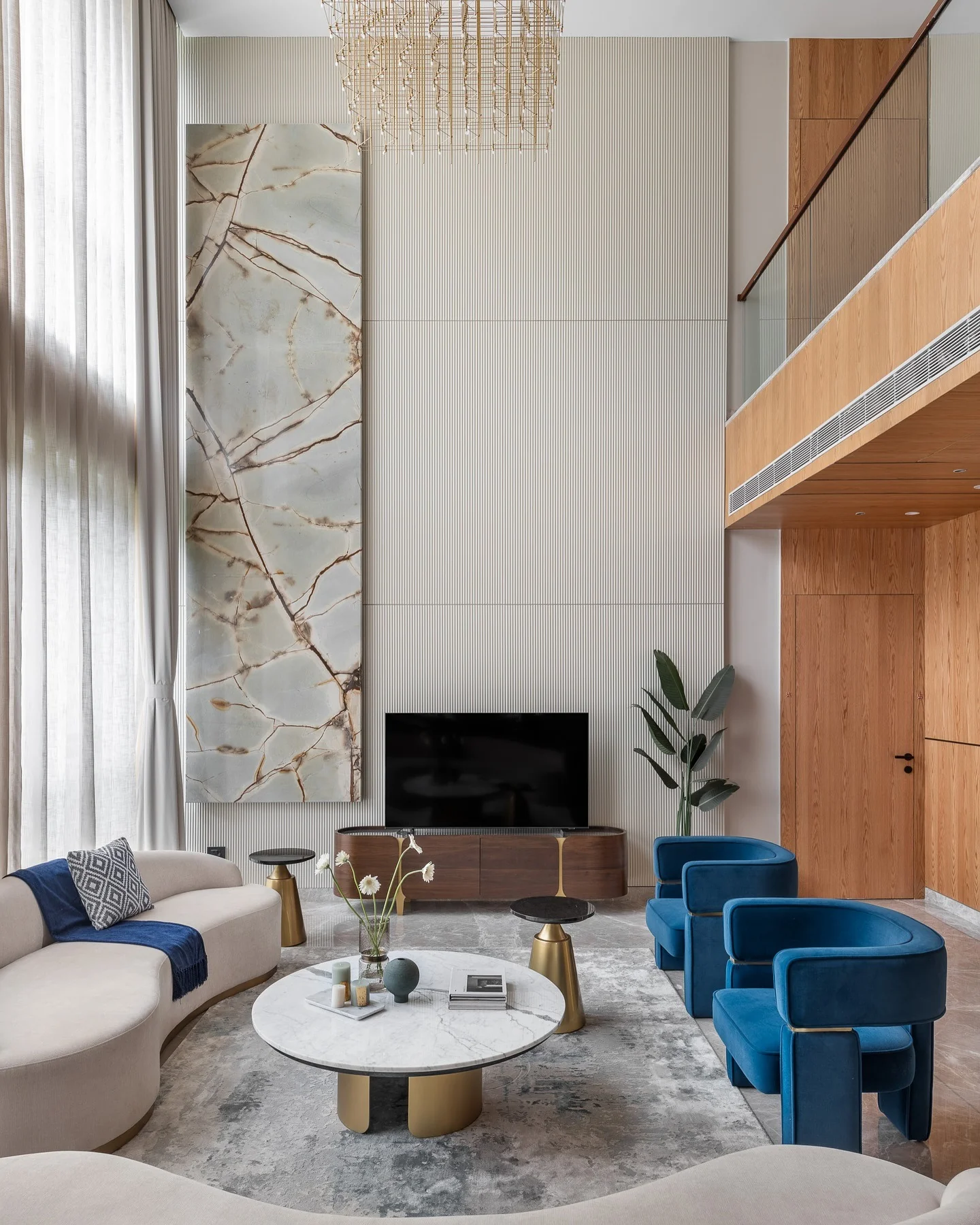 5. High-Ceiling Elegance with Blue Velvet Accents (Royal Blue Living Room Ideas)