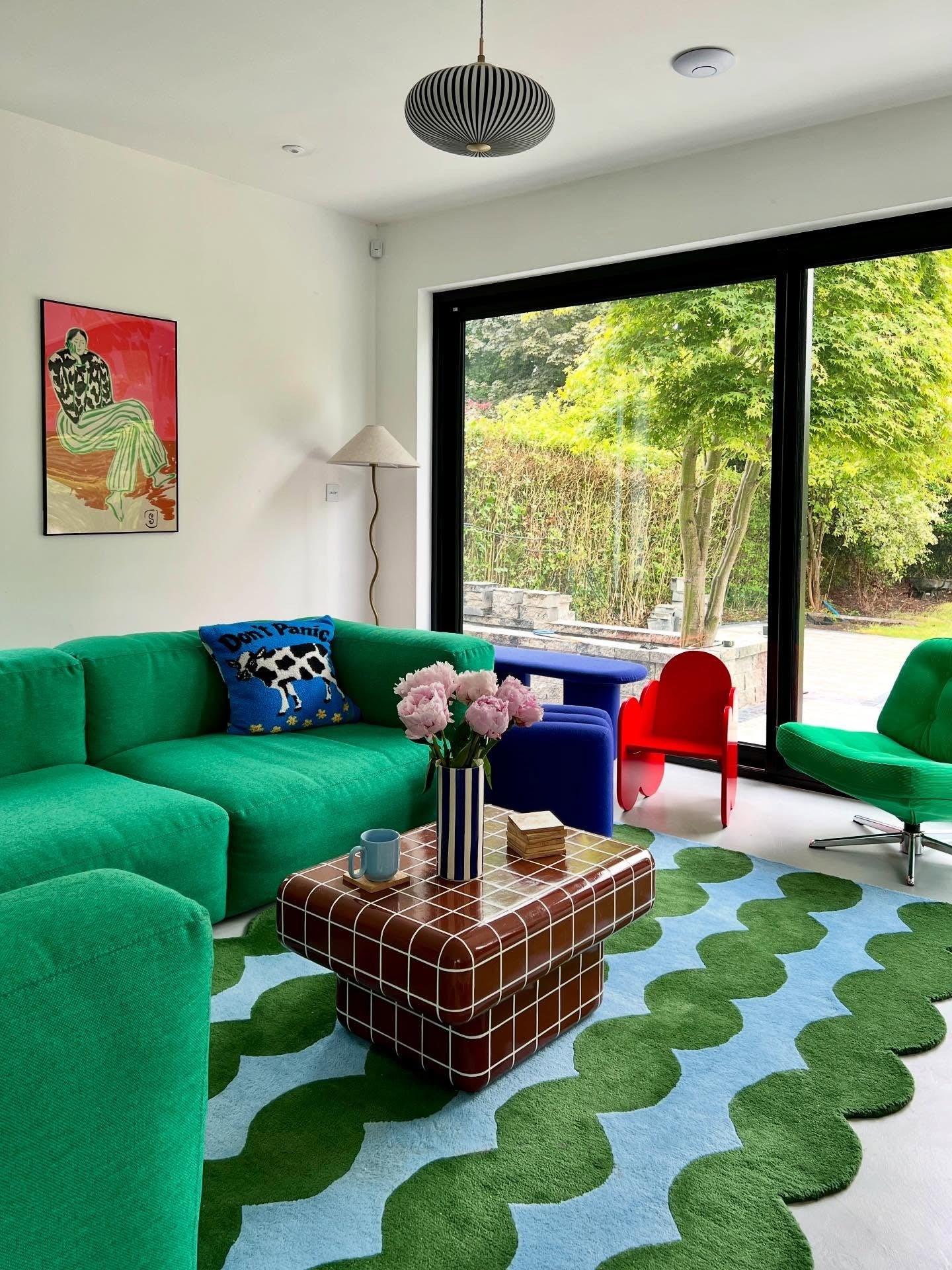 3. Playful Pop Modern Living Room with Emerald Sectional (Green Couch Living Room Ideas)