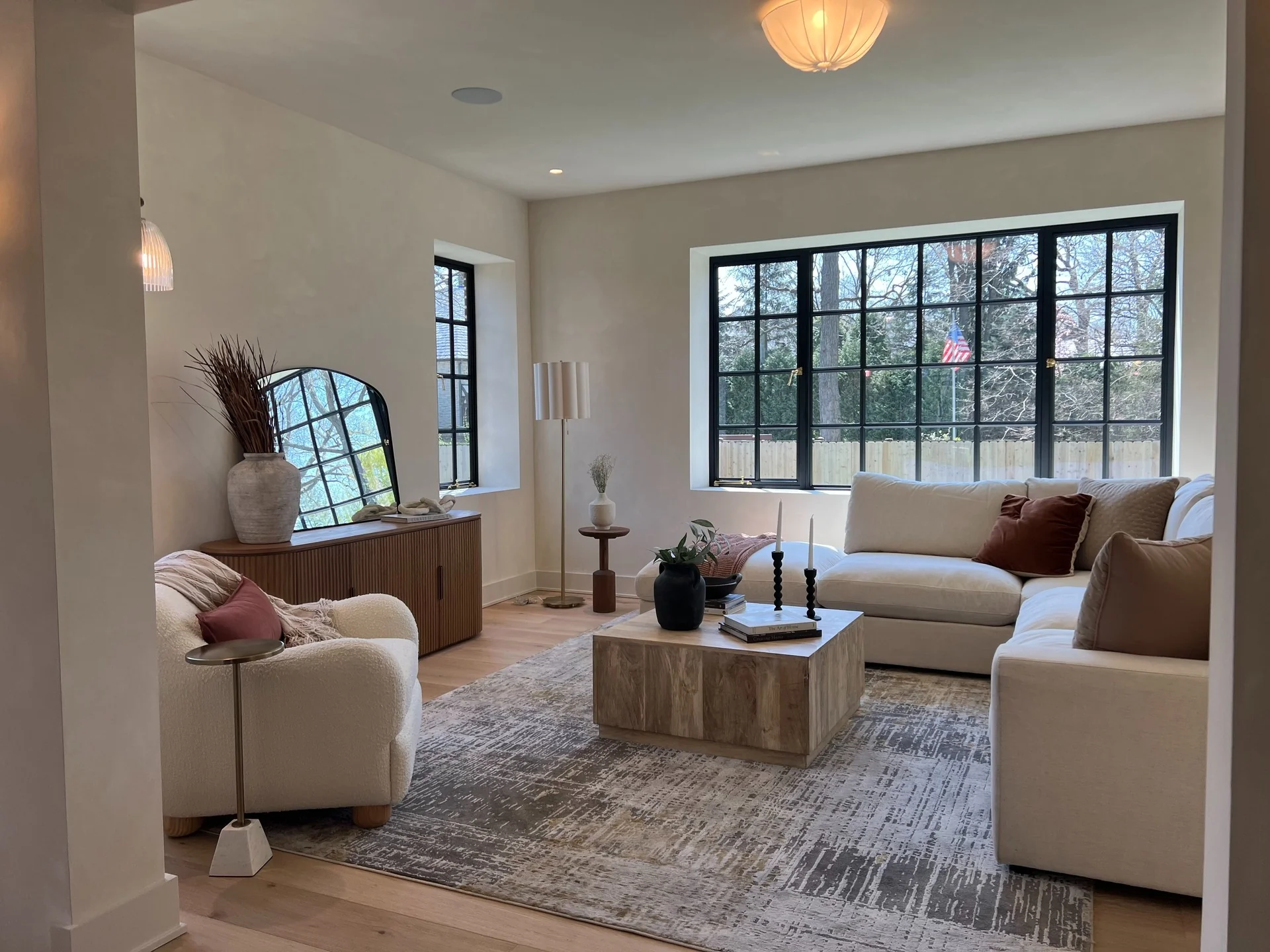 4. Earthy Contemporary with Arched Contrast (Living Room Mirror Ideas)