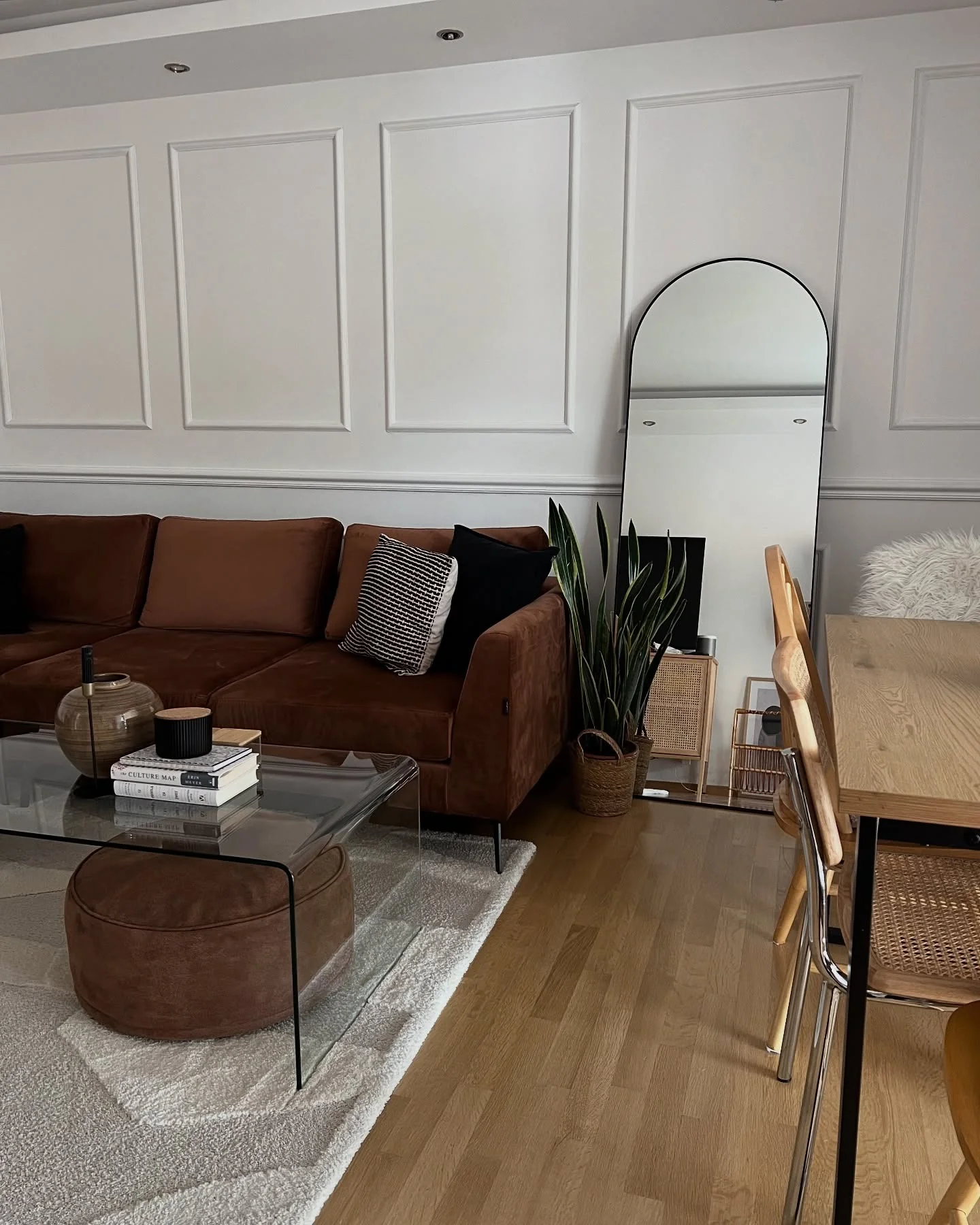 16. Earth-Toned Warmth with Casual Arch Accent (Living Room Mirror Ideas)