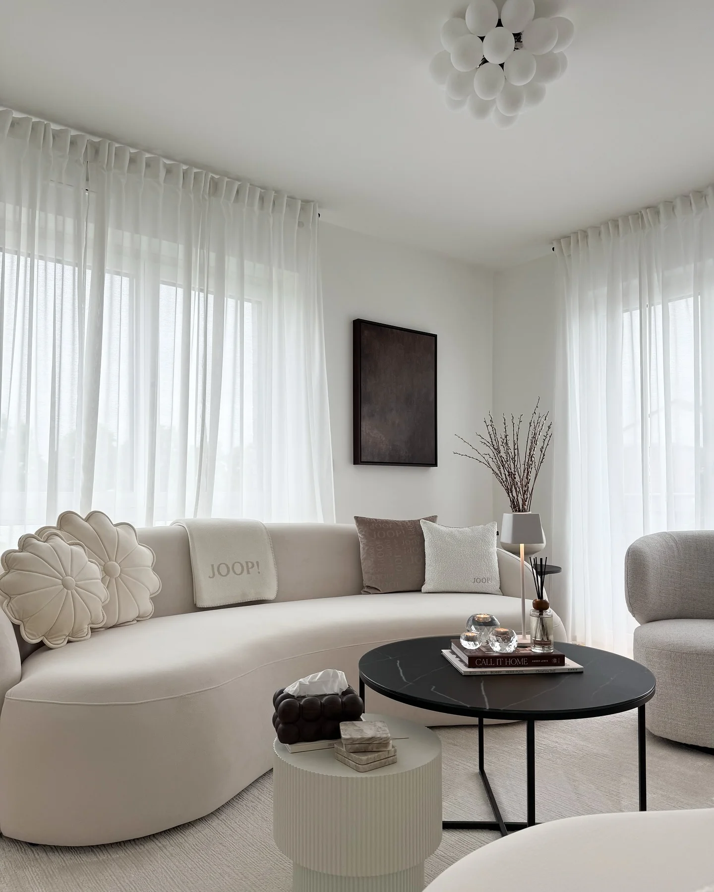 4. Minimal Curves with High Contrast Accents (Beige Couch Living Room Ideas)