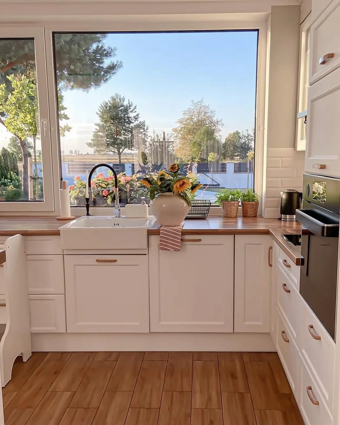 12. Scenic Simplicity Framed by Crisp White Cabinetry and Blonde Wood (Kitchen Window Ideas)