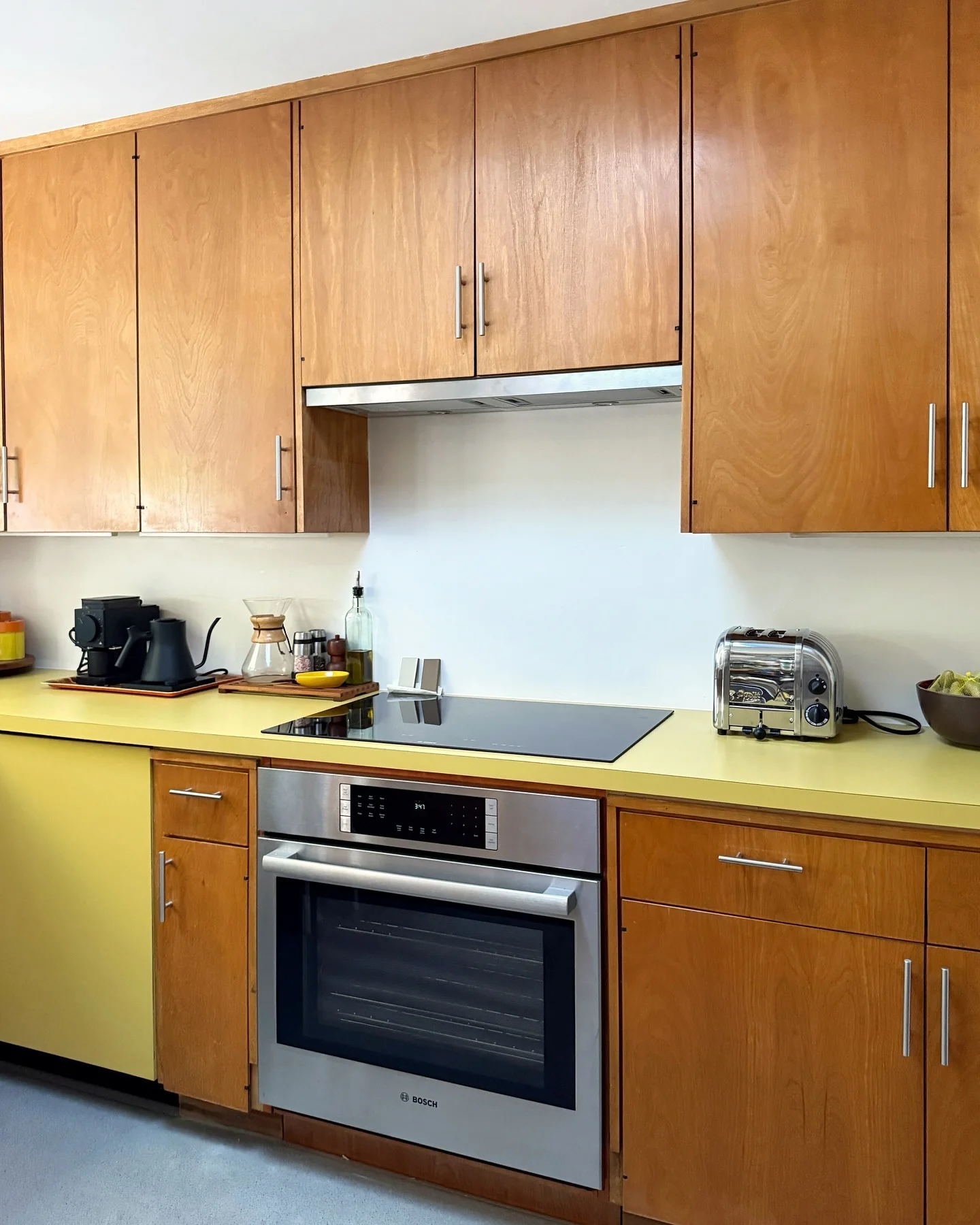 7. Retro-Inspired Simplicity with a Pop of Sunshine (Brown Kitchen Cabinets Ideas)