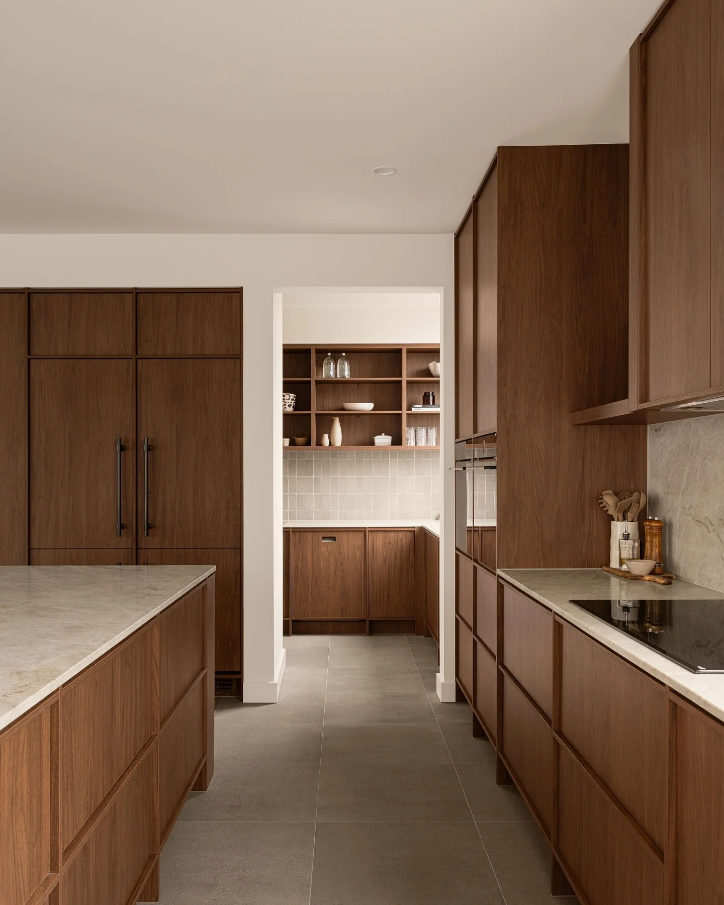 21. Flat-Panel Walnut Cabinets with Warm Minimalism (Brown Kitchen Cabinets Ideas)