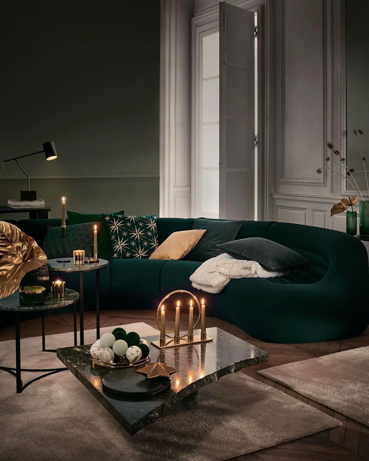 11. Modern Moody Glam: Emerald Curved Sofa with Gold Candlelight (Emerald Green and Gold Living Room Ideas)