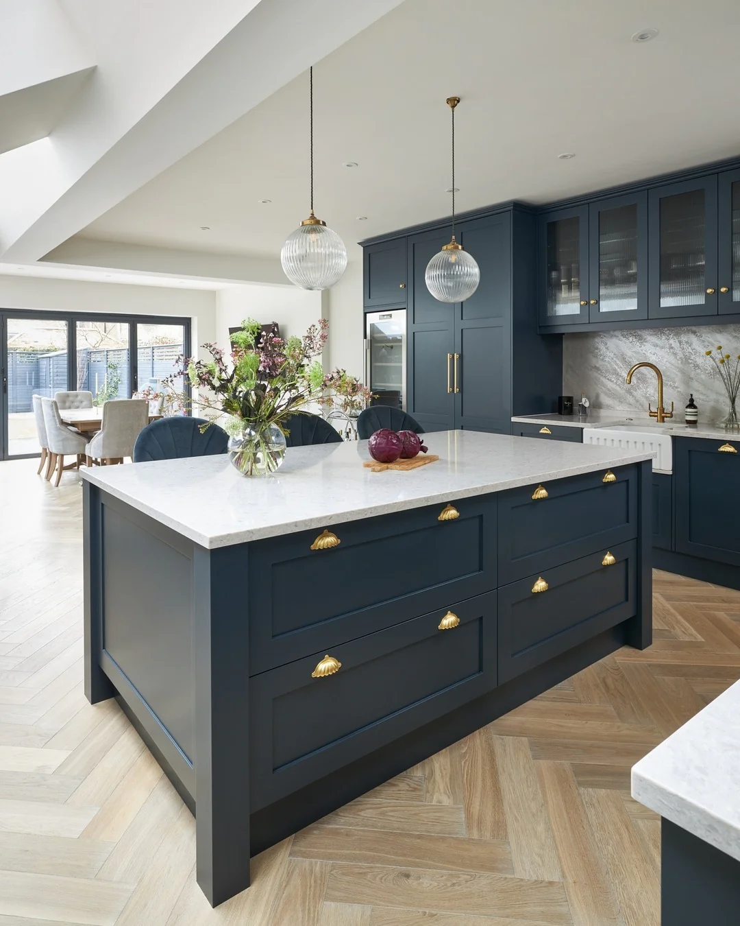 5. Bright Navy Kitchen With Oversized Island, Gold Cup Pulls & Herringbone Floors (Navy Blue Kitchen Cabinets Ideas)
