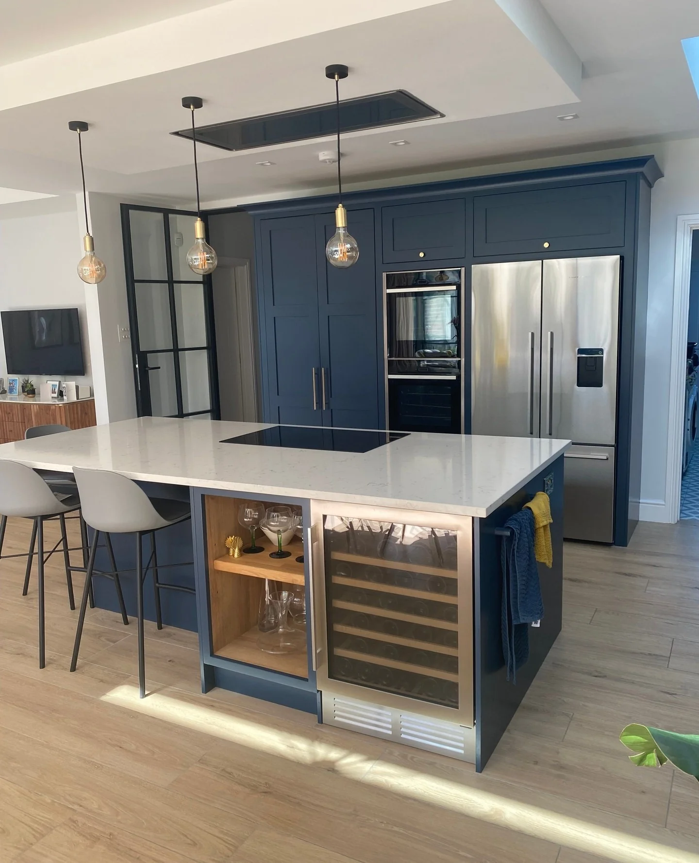 11. Contemporary Navy Kitchen With Oversized Quartz Island & Built-In Wine Fridge (Navy Blue Kitchen Cabinets Ideas)