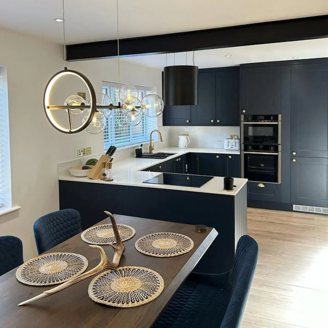 3. Modern Navy L-Shaped Kitchen With White Countertops & Statement Globe Lighting (Navy Blue Kitchen Cabinets Ideas)