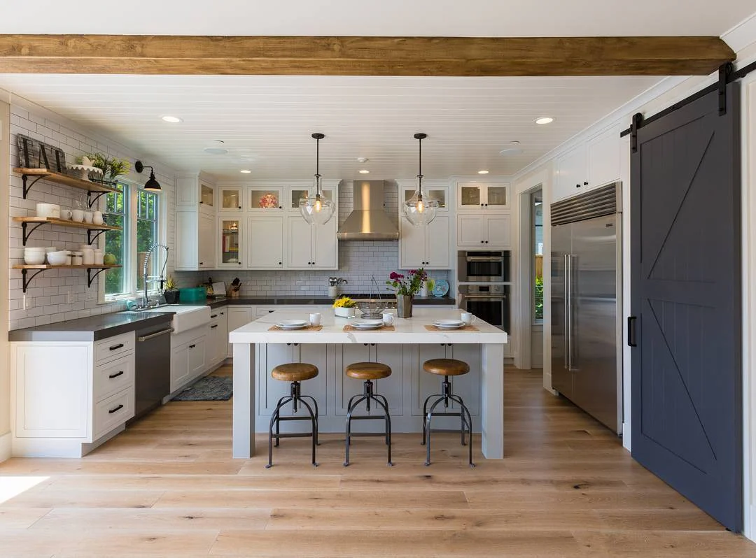 10. Farmhouse Barn Door + Glass Pendants with White Cabinetry and Matte Black Accents (Farmhouse Kitchen Lighting Ideas)